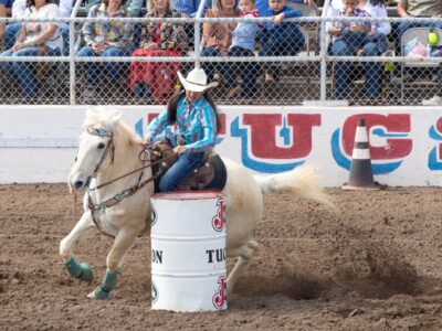 Teenage girl on horse barrel racing.